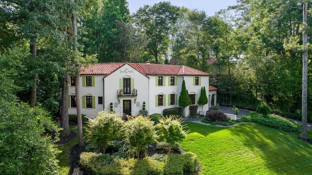 mediterranean / spanish-style house with a front yard and a tiled roof