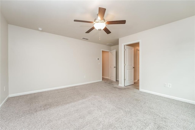 spare room with ceiling fan and light carpet