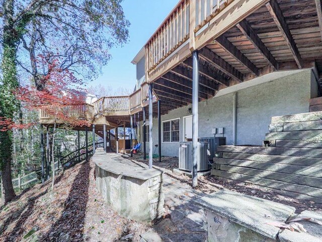 view of side of home with a deck and central AC unit