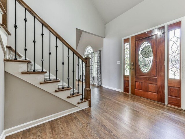 foyer entrance with lofted ceiling and hardwood / wood-style flooring