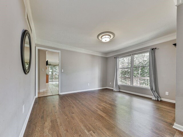 empty room with wood-type flooring and ornamental molding