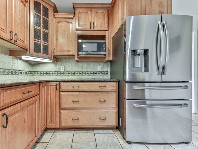 kitchen featuring tasteful backsplash, light stone countertops, and stainless steel appliances