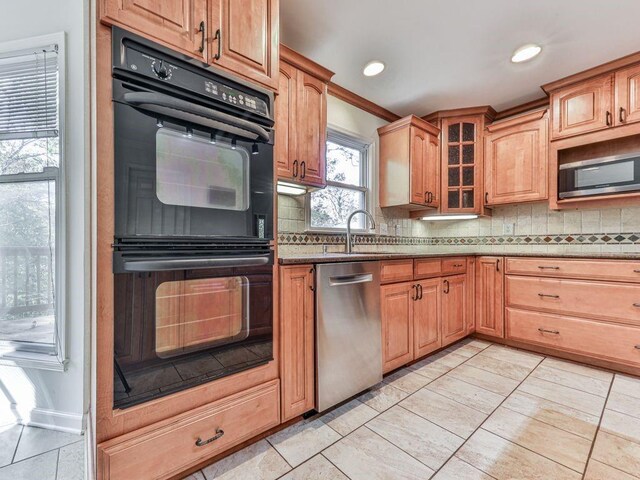 kitchen with backsplash, sink, crown molding, appliances with stainless steel finishes, and light stone counters