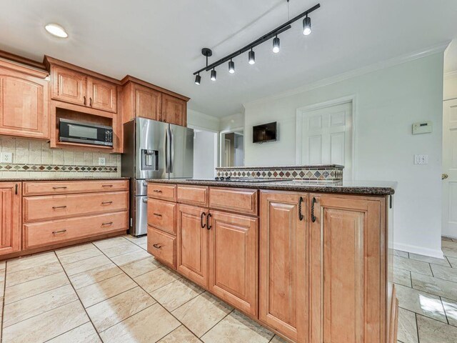 kitchen with appliances with stainless steel finishes, backsplash, crown molding, and dark stone countertops