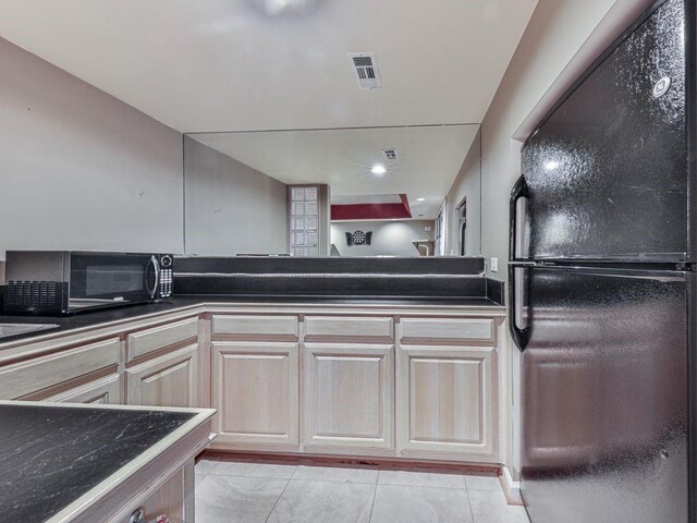 kitchen with light tile patterned floors and black appliances