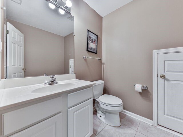 bathroom with tile patterned flooring, vanity, and toilet