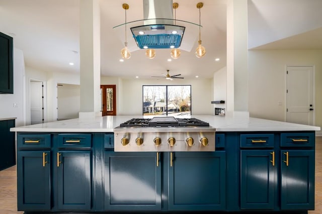 kitchen featuring light stone counters, stainless steel gas cooktop, ceiling fan, and blue cabinets