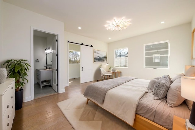 bedroom featuring wood-type flooring and a barn door