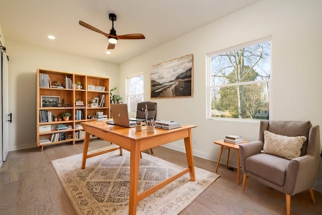 home office featuring hardwood / wood-style flooring, plenty of natural light, and ceiling fan