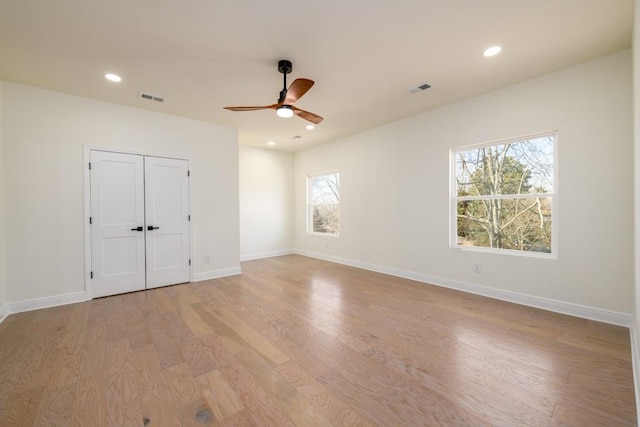 unfurnished bedroom featuring ceiling fan, light hardwood / wood-style floors, and a closet