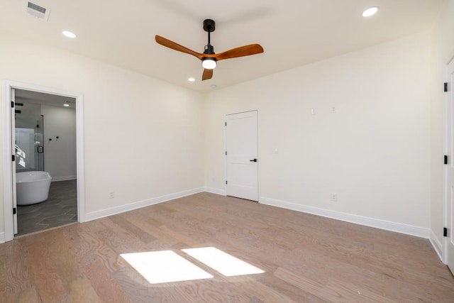 unfurnished bedroom with ceiling fan, ensuite bath, and light hardwood / wood-style flooring