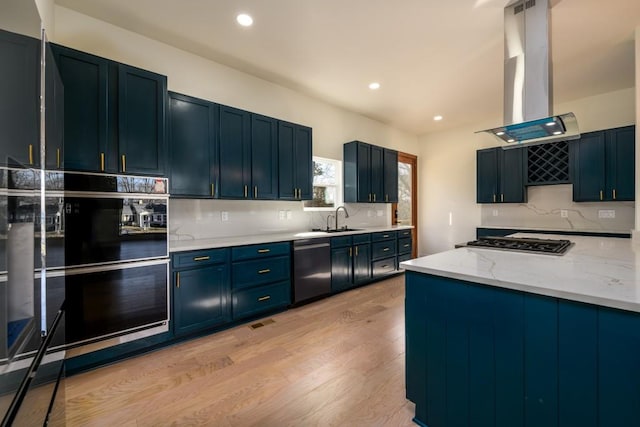 kitchen with light stone counters, island exhaust hood, stainless steel appliances, light hardwood / wood-style floors, and backsplash