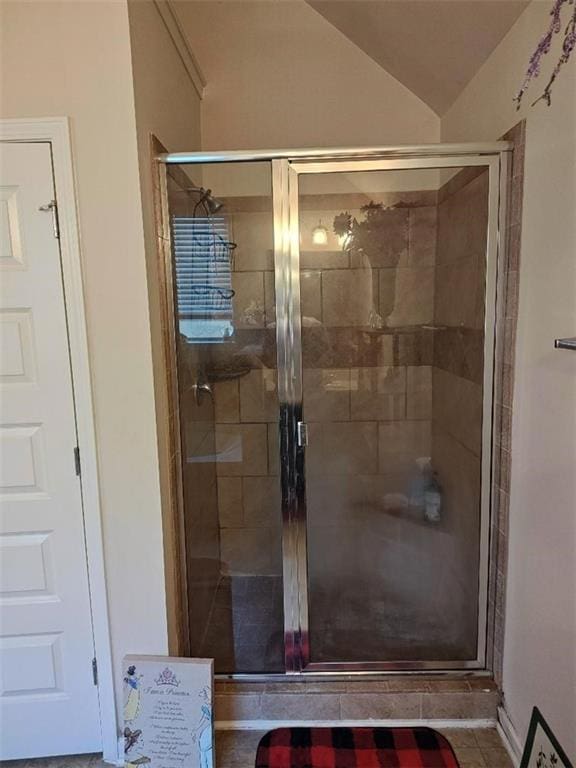 bathroom featuring tile patterned flooring, lofted ceiling, and walk in shower