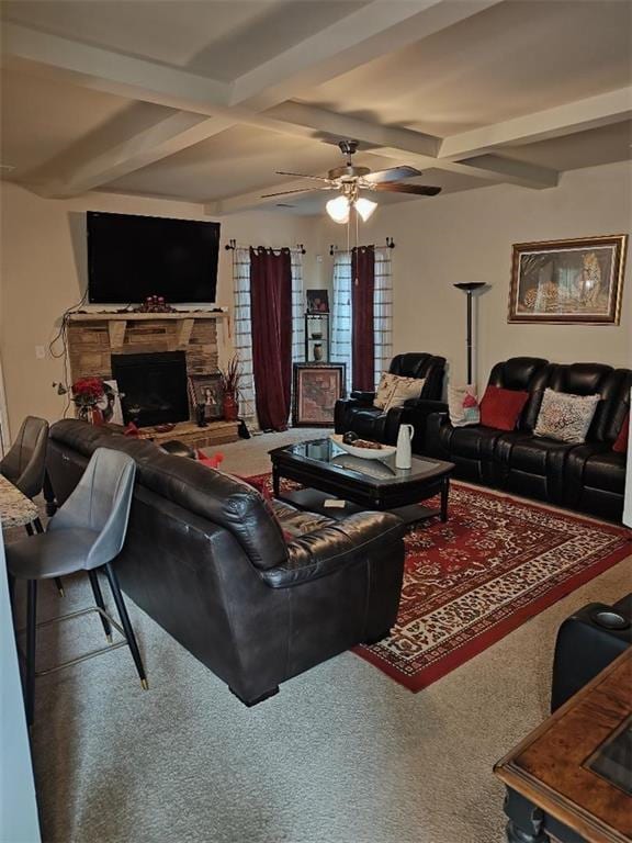 living room featuring beamed ceiling, ceiling fan, a fireplace, and carpet