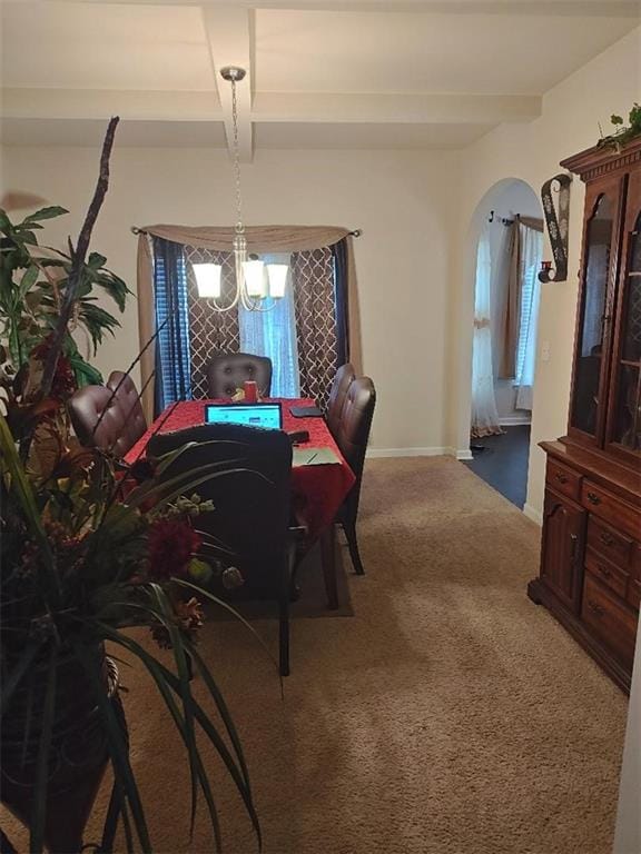 dining area with carpet flooring, a notable chandelier, and beamed ceiling