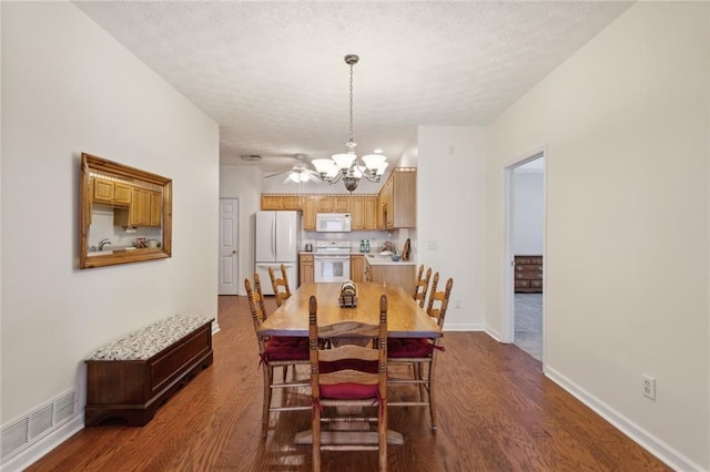 dining space featuring an inviting chandelier, dark hardwood / wood-style floors, and a textured ceiling