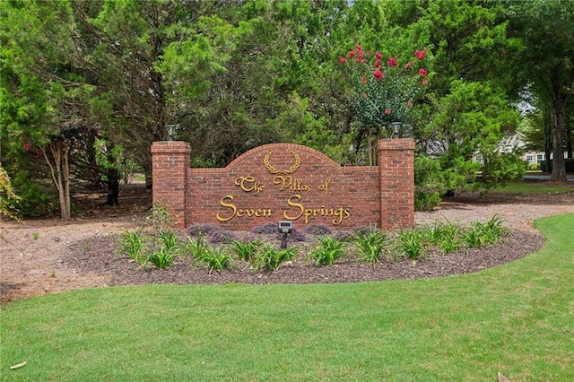 community / neighborhood sign with a yard