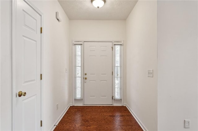 entryway with dark hardwood / wood-style floors and a textured ceiling