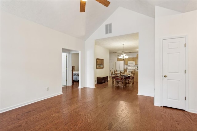 unfurnished room featuring high vaulted ceiling, dark hardwood / wood-style flooring, and ceiling fan with notable chandelier