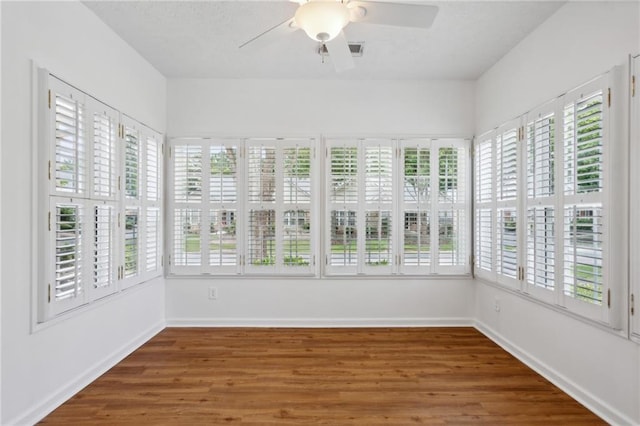 unfurnished sunroom with ceiling fan