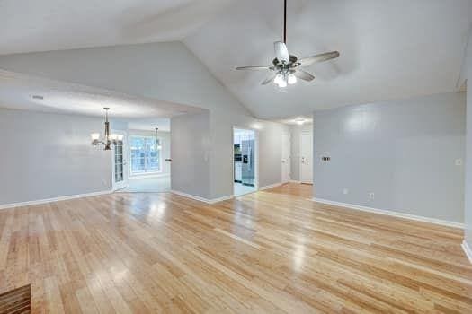 2105 Huntington Hills Trce, Buford, GA 30519 - unfurnished living room with a chandelier, a ceiling fan, light wood-style flooring, and high vaulted ceiling