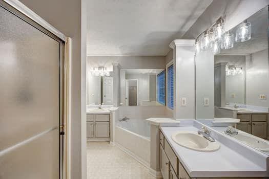 2105 Huntington Hills Trce, Buford, GA 30519 - full bath with two vanities, a shower stall, and a garden tub