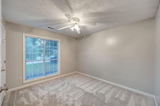 2105 Huntington Hills Trce, Buford, GA 30519 - unfurnished room featuring ceiling fan, carpet, and a textured ceiling