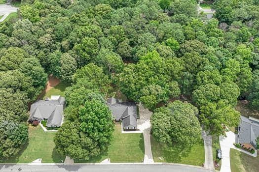 2105 Huntington Hills Trce, Buford, GA 30519 - aerial view of property and surrounding area featuring a heavily wooded area