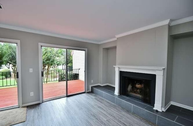 6500 Gaines Ferry Rd Unit A2, Flowery Branch, GA 30542 - unfurnished living room featuring a fireplace with raised hearth, healthy amount of natural light, wood finished floors, baseboards, and crown molding