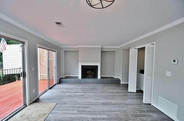 6500 Gaines Ferry Rd Unit A2, Flowery Branch, GA 30542 - unfurnished living room featuring wood finished floors, ornamental molding, a tile fireplace, and baseboards