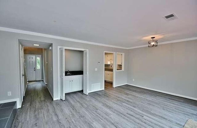 6500 Gaines Ferry Rd Unit A2, Flowery Branch, GA 30542 - unfurnished living room with dark wood-style floors, ornamental molding, baseboards, and a sink