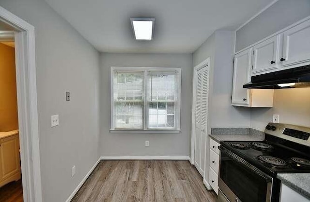 6500 Gaines Ferry Rd Unit A2, Flowery Branch, GA 30542 - kitchen featuring stainless steel electric range oven, wood finished floors, under cabinet range hood, white cabinets, and baseboards