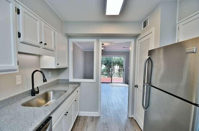 6500 Gaines Ferry Rd Unit A2, Flowery Branch, GA 30542 - kitchen with stainless steel appliances, a sink, white cabinets, light wood-style flooring, and baseboards