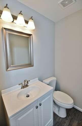 6500 Gaines Ferry Rd Unit A2, Flowery Branch, GA 30542 - bathroom featuring vanity, toilet, wood finished floors, and baseboards