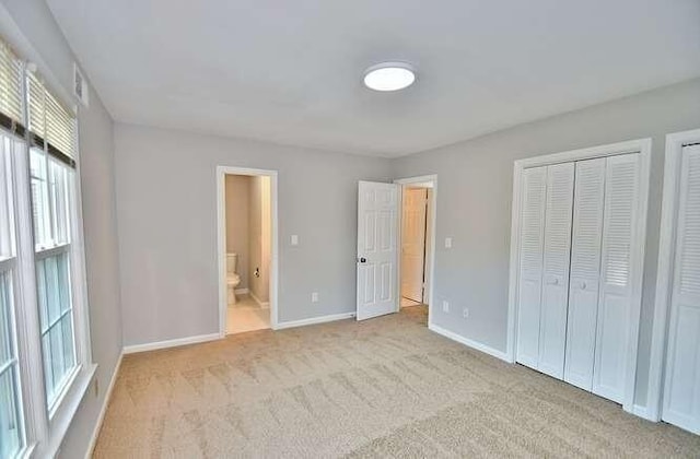 6500 Gaines Ferry Rd Unit A2, Flowery Branch, GA 30542 - unfurnished bedroom with baseboards, carpet flooring, and connected bathroom