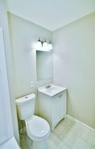 6500 Gaines Ferry Rd Unit A2, Flowery Branch, GA 30542 - bathroom featuring vanity, toilet, tile patterned floors, and baseboards