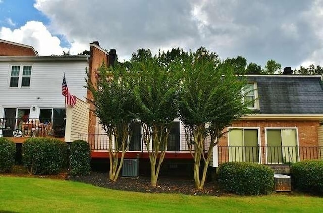 6500 Gaines Ferry Rd Unit A2, Flowery Branch, GA 30542 - rear view of property with a chimney, central AC unit, a wooden deck, and a yard