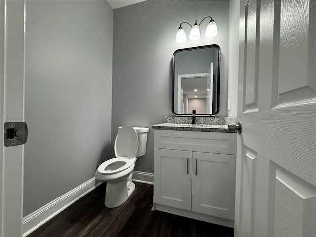 bathroom with wood-type flooring, vanity, and toilet