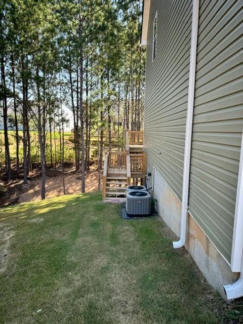 view of yard with central AC and a wooden deck