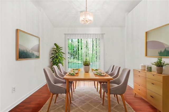 dining room with a chandelier, baseboards, and wood finished floors