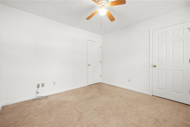 empty room featuring light carpet, baseboards, and a ceiling fan