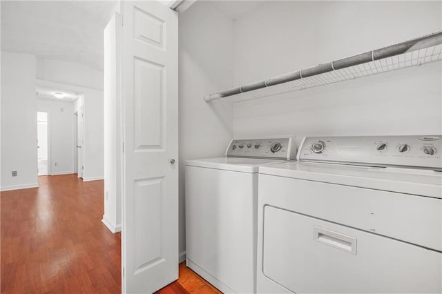 laundry room featuring baseboards, light wood finished floors, separate washer and dryer, and laundry area