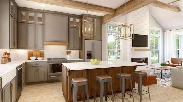 kitchen featuring stainless steel appliances, a large fireplace, backsplash, and light hardwood / wood-style flooring