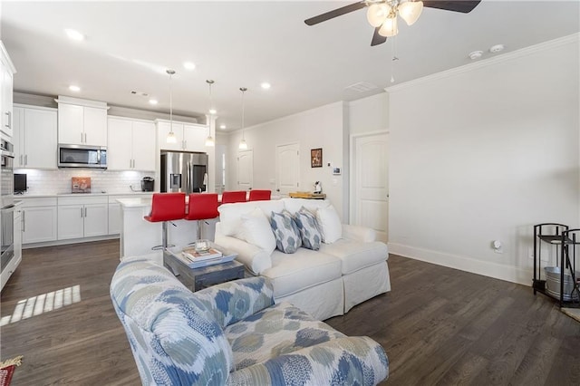 living area featuring dark wood-style flooring, baseboards, ceiling fan, and ornamental molding