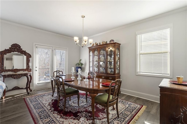 dining space featuring a chandelier, dark wood finished floors, baseboards, and ornamental molding