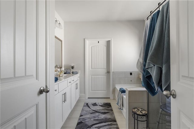 bathroom featuring tile patterned floors, a bath, and vanity