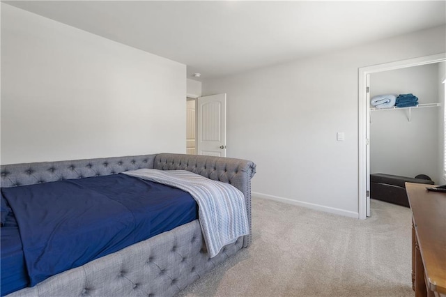 bedroom with a walk in closet, carpet flooring, baseboards, and a closet