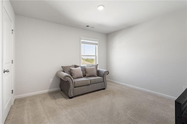 sitting room featuring light colored carpet, visible vents, and baseboards