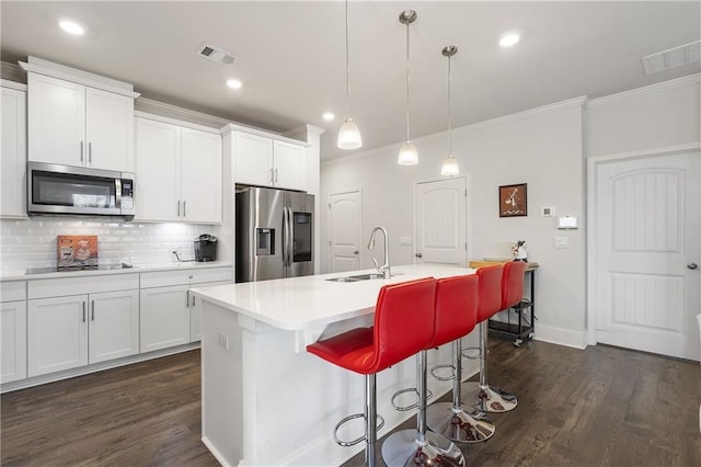 kitchen featuring a sink, stainless steel appliances, visible vents, and a center island with sink