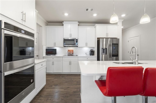 kitchen featuring a sink, visible vents, appliances with stainless steel finishes, and ornamental molding